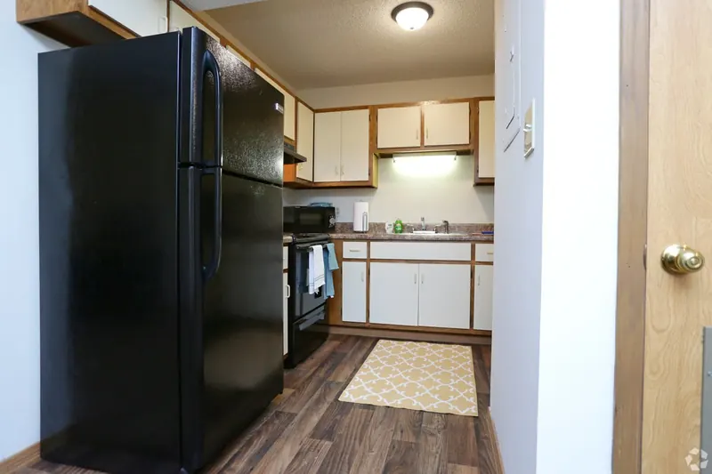 Kitchen with a black refrigerator and white cabinets