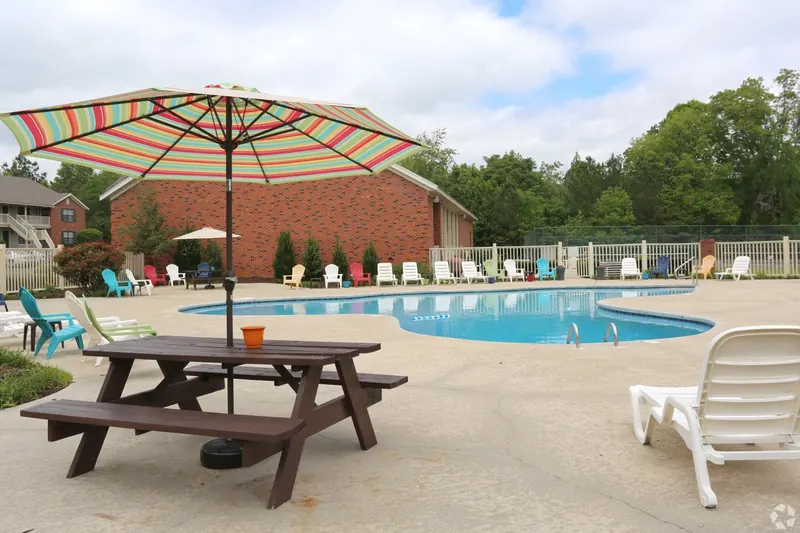 Pool deck with a picnic table and umbrella
